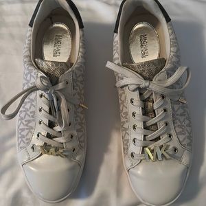 Michael Kors Poppy Sneaker with gold insignia. This sneaker is 7.5. Block logo